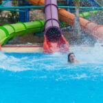three slides at the water park rolls out of the middle child, splashing water