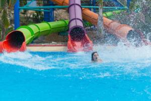 three slides at the water park rolls out of the middle child, splashing water