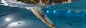 Young man swimming in pool. Concept of healthy lifestyle. Underwater photography