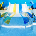 view from the top on colorful plastic water-slide in swimming pool. Blur aperture